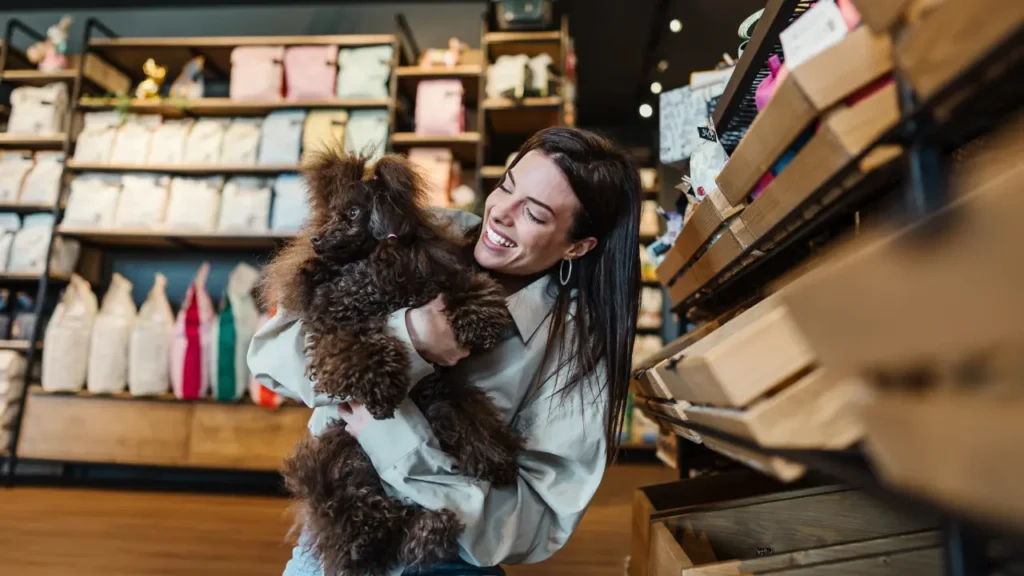 Young woman with poodle in pet shop